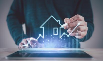 Futuristic image of a house being drawn on a screen in front of an arrow going up, indicating growth